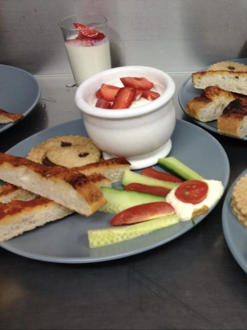 Assiette de brunch fermier avec yaourt aux fraises, pain toasté, crudités et cookie maison